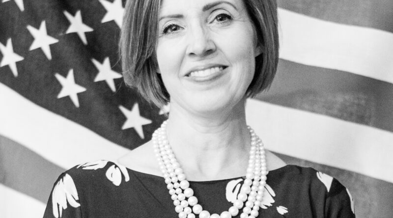 A grayscale image of a woman with the US flag background