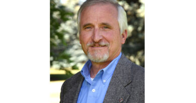 A portrait of a man with white goatee and hair