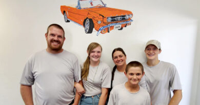 A family with a car artwork above them