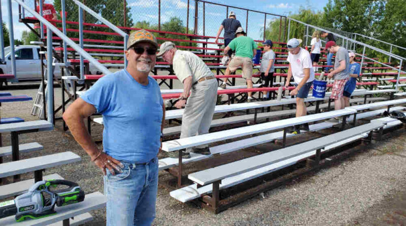 People cleaning the bleachers