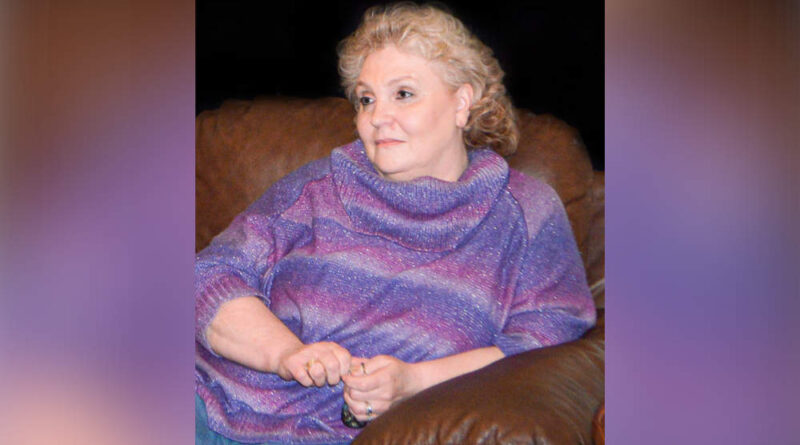 A woman wearing a purple sweater on the sofa