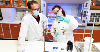 Scientists Matt Snow and Jessica Ward hold a natural vanadium solution