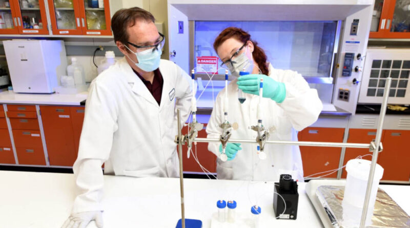 Scientists Matt Snow and Jessica Ward hold a natural vanadium solution
