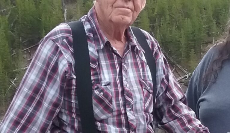 An elderly man wearing a checkered top