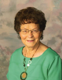 An elderly woman wearing a green apparel