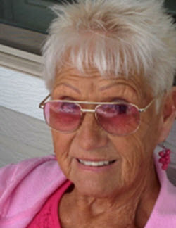 An elderly woman with pink accessories