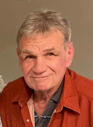 An elderly man wearing a brown top