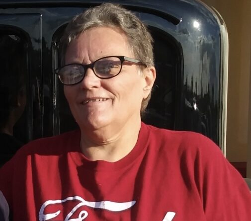 A woman wearing glasses squinting at the sun